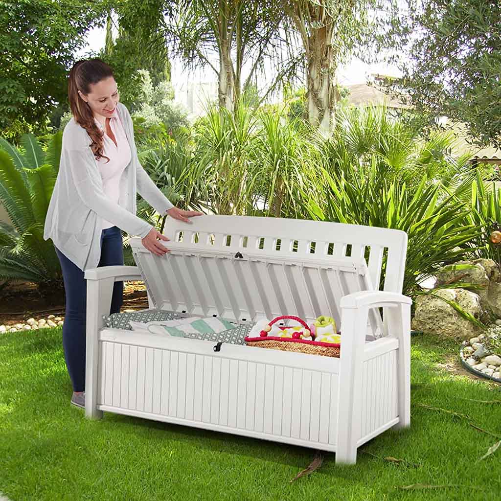 Mujer joven abre arcón de Banco Keter blanco con baúl en Jardin