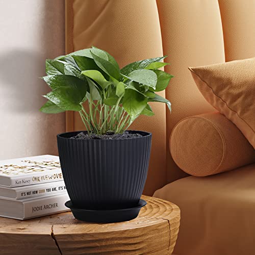 Macetas negras con plato de drenaje y planta en mesita en interior Warmplus