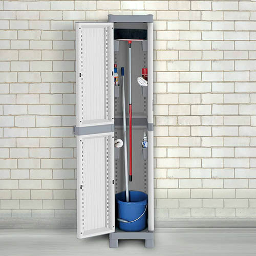 Escobero alto de un cuerpo con puerta abierta y enseres de limpieza en su interior sobre fondo de ladrillo de garaje