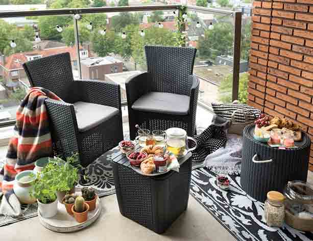Conjunto Keter Iowa color antracita en amplio balcón con desayuno y plantas