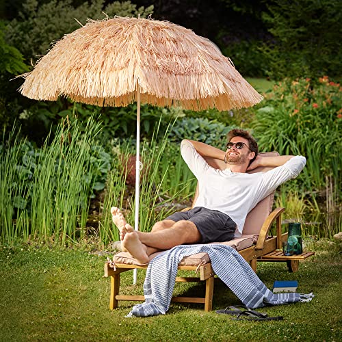 Tomando el sol en el jardín con la Sombrilla de Playa Hawaiana Ø 160cm Inclinable de Rafia o paja  Color Natural. Kingsleeve 