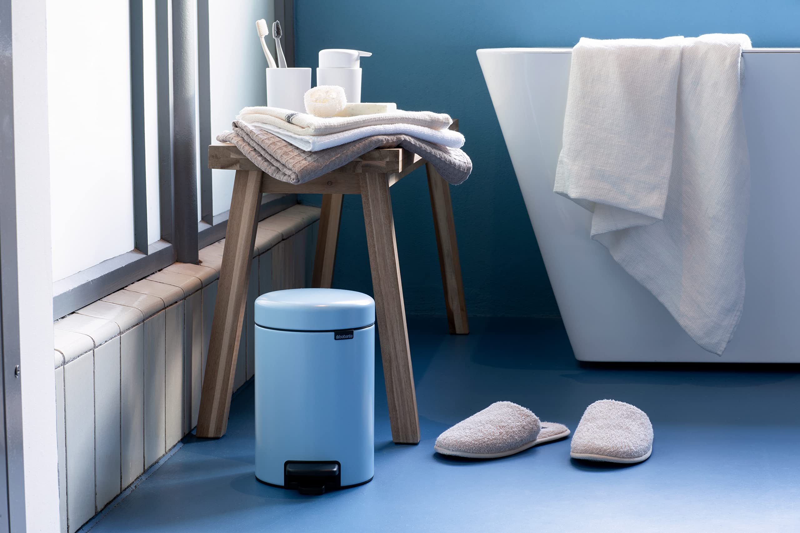 Papelera azul claro Brabantia en ambiente de cuarto de baño  