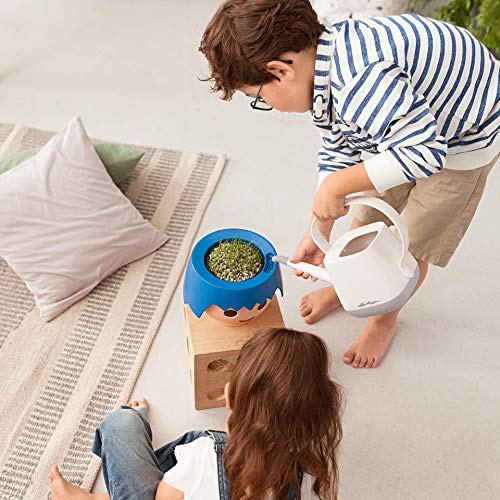 Macetero OJO Ocean Blue con diseño de cabeza de muñeco Playmobil en interior con niños en proceso de riego