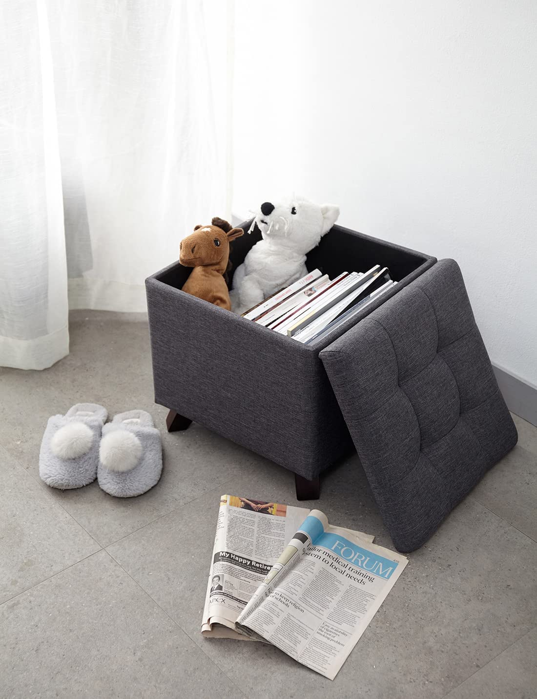 Ambiente de salón con almacenaje de libros en el Puff Asiento con Baúl de Almacenamiento Elegante con Patas de Madera Maciza tapizado tipo lino Gris. Suhu