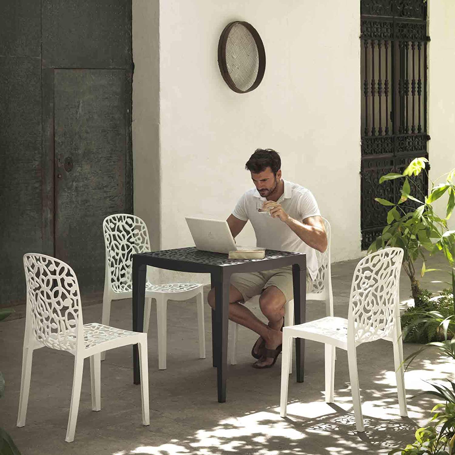 Patio exterior con el juego de 6 Sillas apilables de interior exterior Flora. 87x50x47 cm, blanco, hecho en España. Shaf