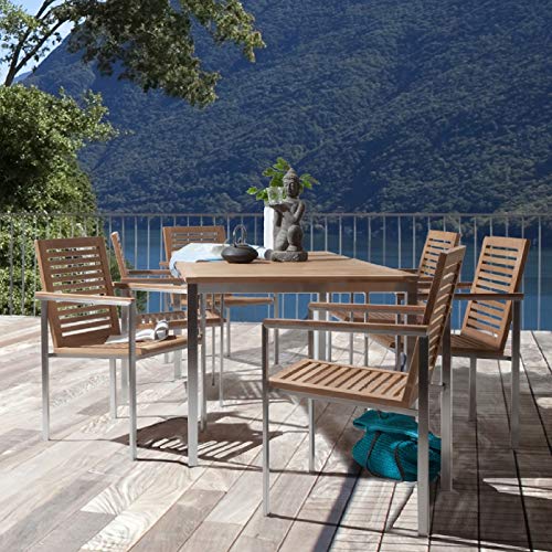 Vista en terraza de conjunto de mesa y juego de Sillas apilables de jardín de madera de teca y acero inoxidable con reposabrazos. CHICREAT  