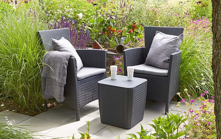 Conjunto Keter Iowa en Rattán de exterior e interior con cojín incluido color grafito en terraza. Keter