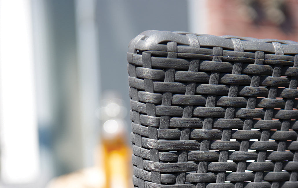 Detalle cercano de respaldo de tejido rattán del Conjunto Keter Iowa en Rattán de exterior e interior con cojín incluido color capuchino en terraza. Keter