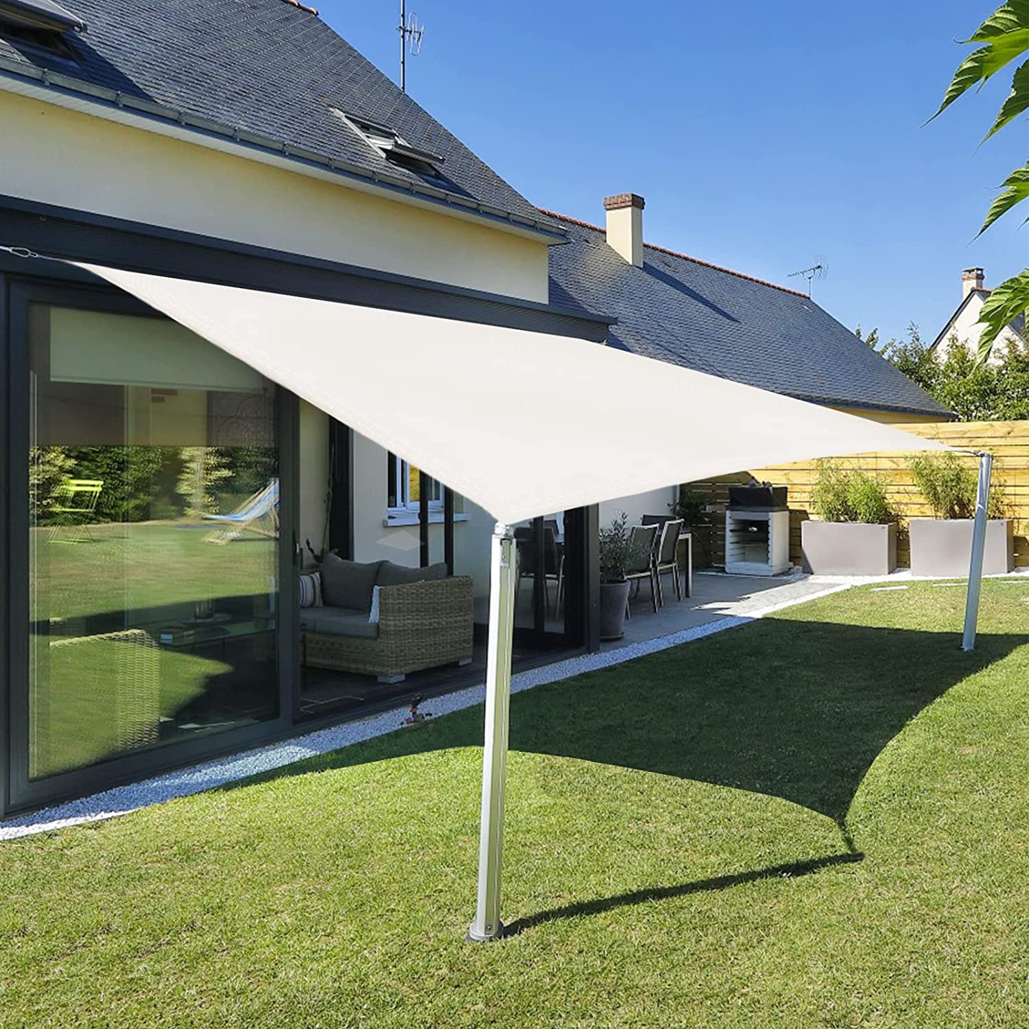 Vista en bonito jardín con la sombra fresquita de la Vela de sombra 2x2 m. Impermeable Color Crema que bloquea más del 95% de la radiación UV. Sunnylaxx.