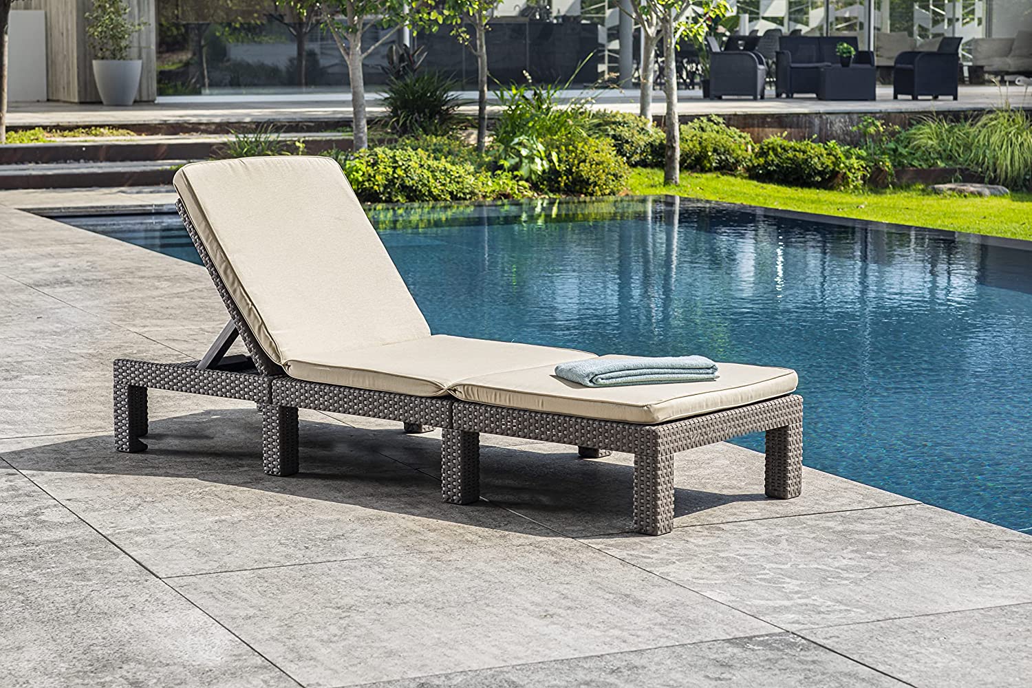 Tumbona keter Daytona para jardín color marrón y cojines beige junto a piscina